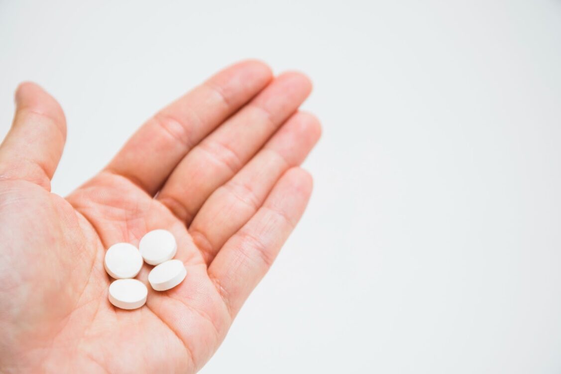 Round white pills on hand