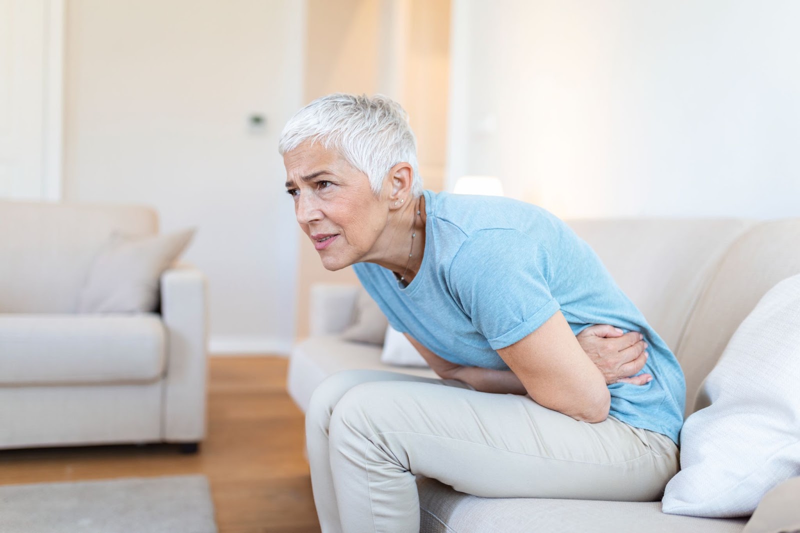 Woman holding belly feeling discomfort