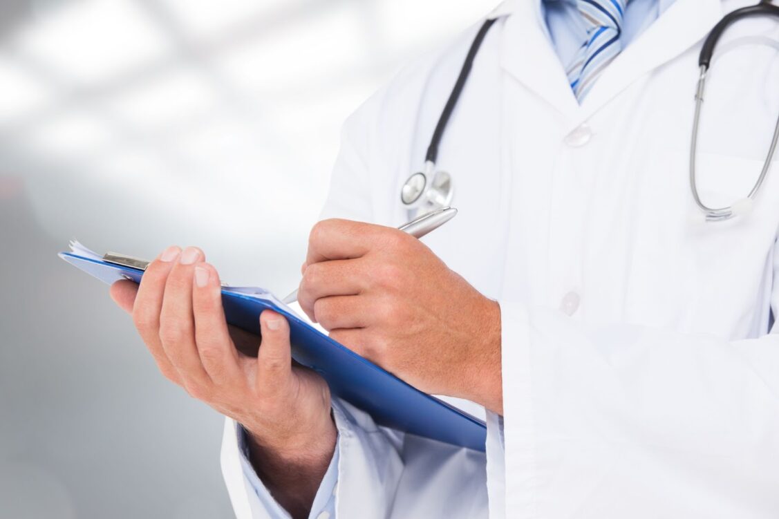 Close up of doctor writing information about patient