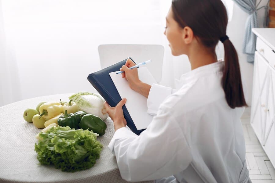 The girl in the white coat is looking at the fruit